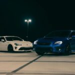 Biały i niebieski sportowy samochód zaparkowane nocą na dachu parkingu