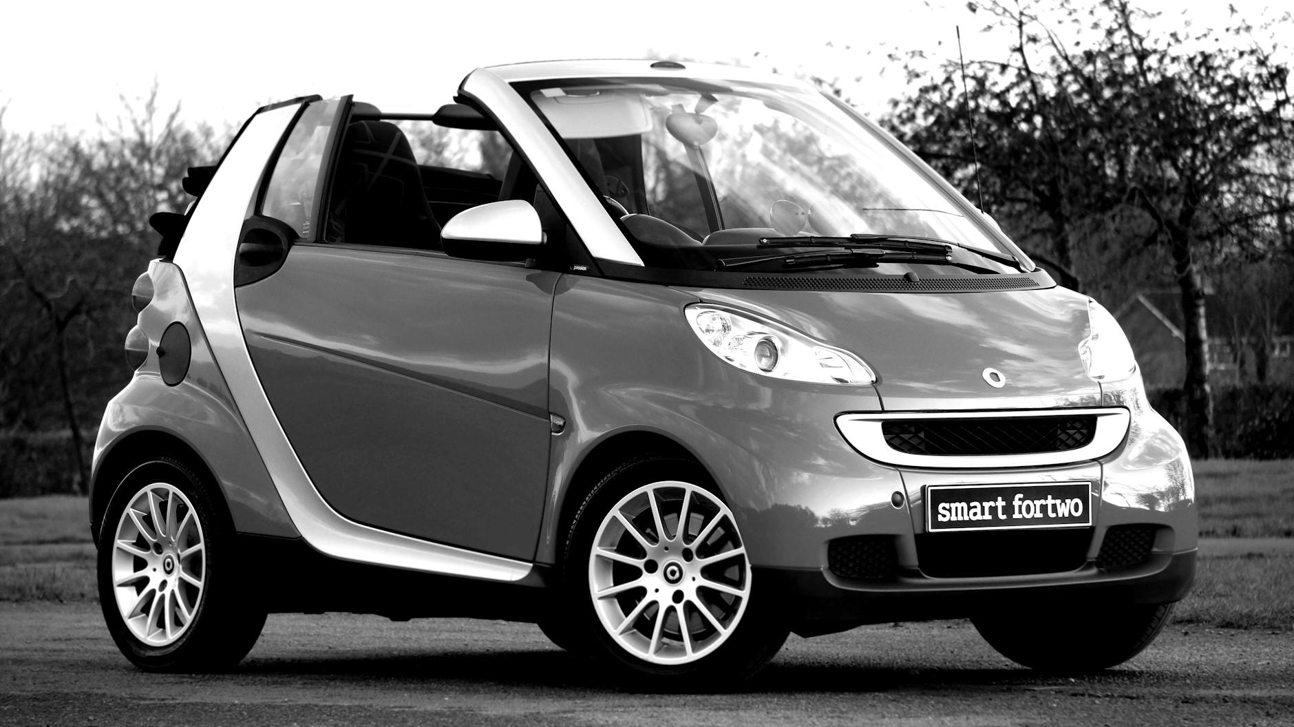 Czarno-białe zdjęcie kabrioletu Smart Fortwo zaparkowanego na zewnątrz
