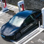 Czarne auto elektryczne przy miejskiej stacji ładowania