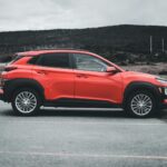 Czerwona Toyota C-HR zaparkowana na zewnątrz w pochmurny dzień