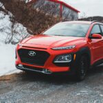 Czerwony SUV Changan zaparkowany na śniegu, widok z boku