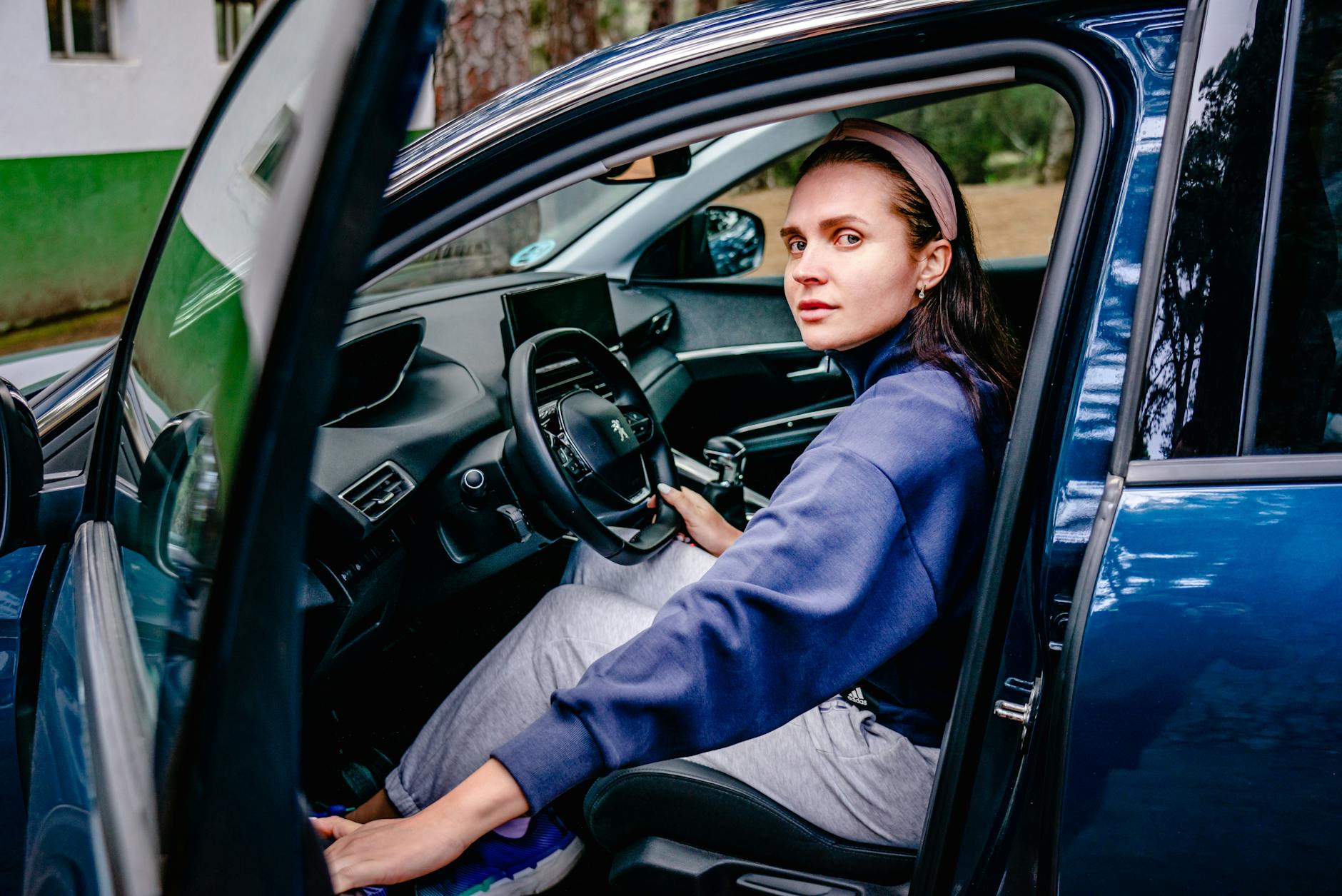 Młoda kobieta za kierownicą samochodu VW z otwartymi drzwiami