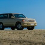 Beżowe Volvo SUV zaparkowane na pustynnym terenie pod błękitnym niebem