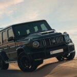 Czarne Maserati Grecale jedzie po pustynnych piaskach o zmierzchu