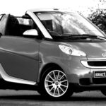 Czarno-białe zdjęcie klasycznego kabrioletu Smart Fortwo na ulicy