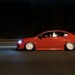 Czerwony Chevrolet Corvette jedzie nocą autostradą z efektem rozmycia