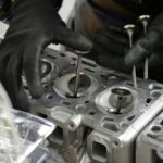 Mechanik pracuje przy głowicy silnika hybrydowej Toyoty