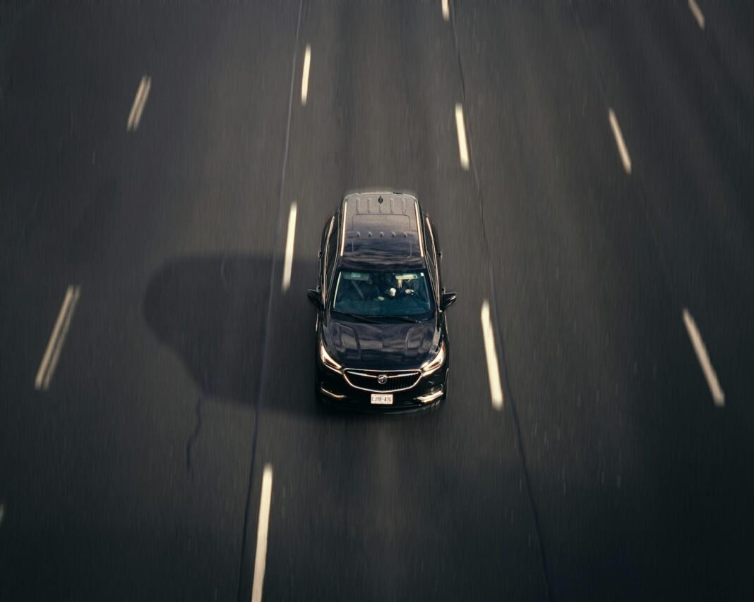 Czarna Skoda Superb 2.0 TDI jedzie autostradą w dużym mieście