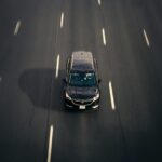 Czarna Skoda Superb 2.0 TDI jedzie autostradą w dużym mieście