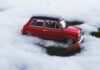 Czerwony model auta na śniegu symbolizujący zimową jazdę Suzuki