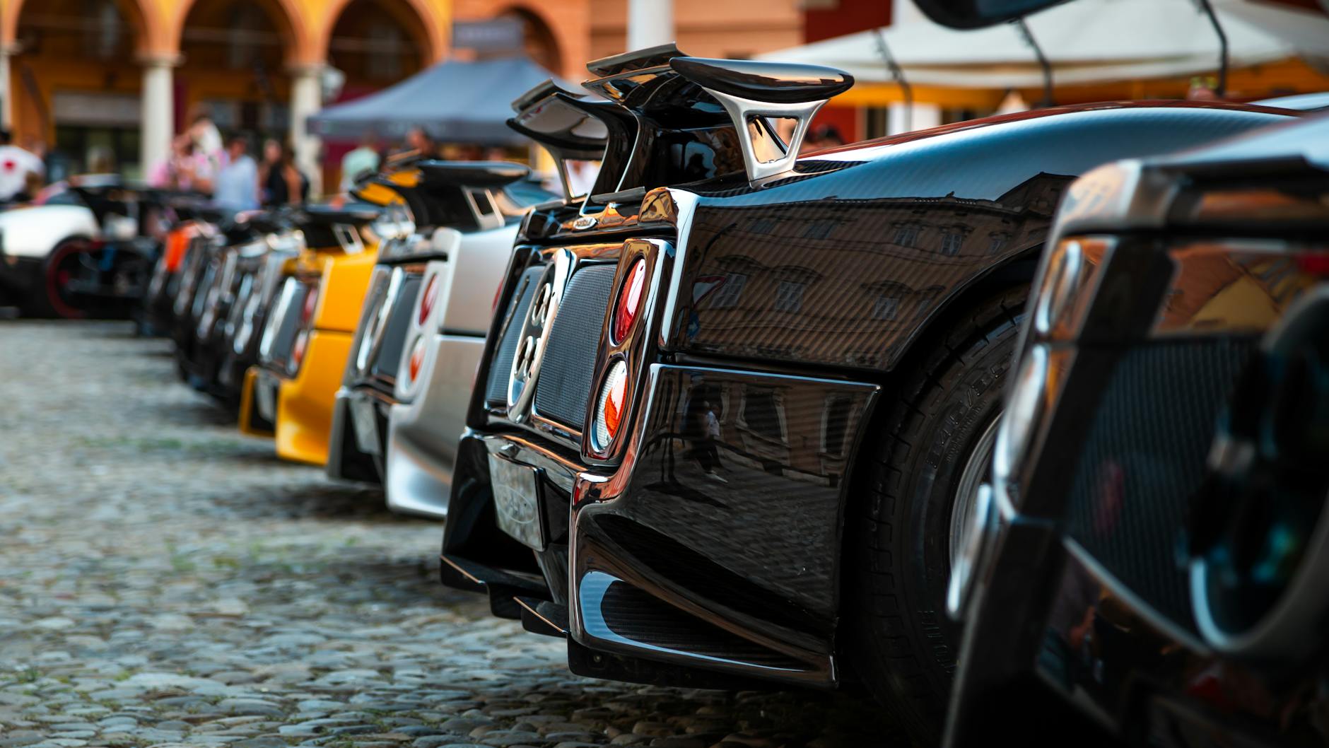 Luksusowe sportowe auta Aston Martin ustawione w rzędzie na zewnątrz