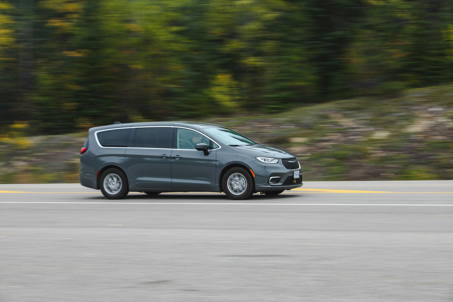 Nowoczesny minivan jedzie szybko autostradą wśród zieleni