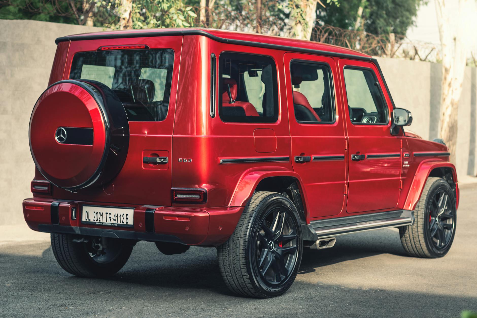 Czerwony SUV Mercedes G-Class zaparkowany na zewnątrz