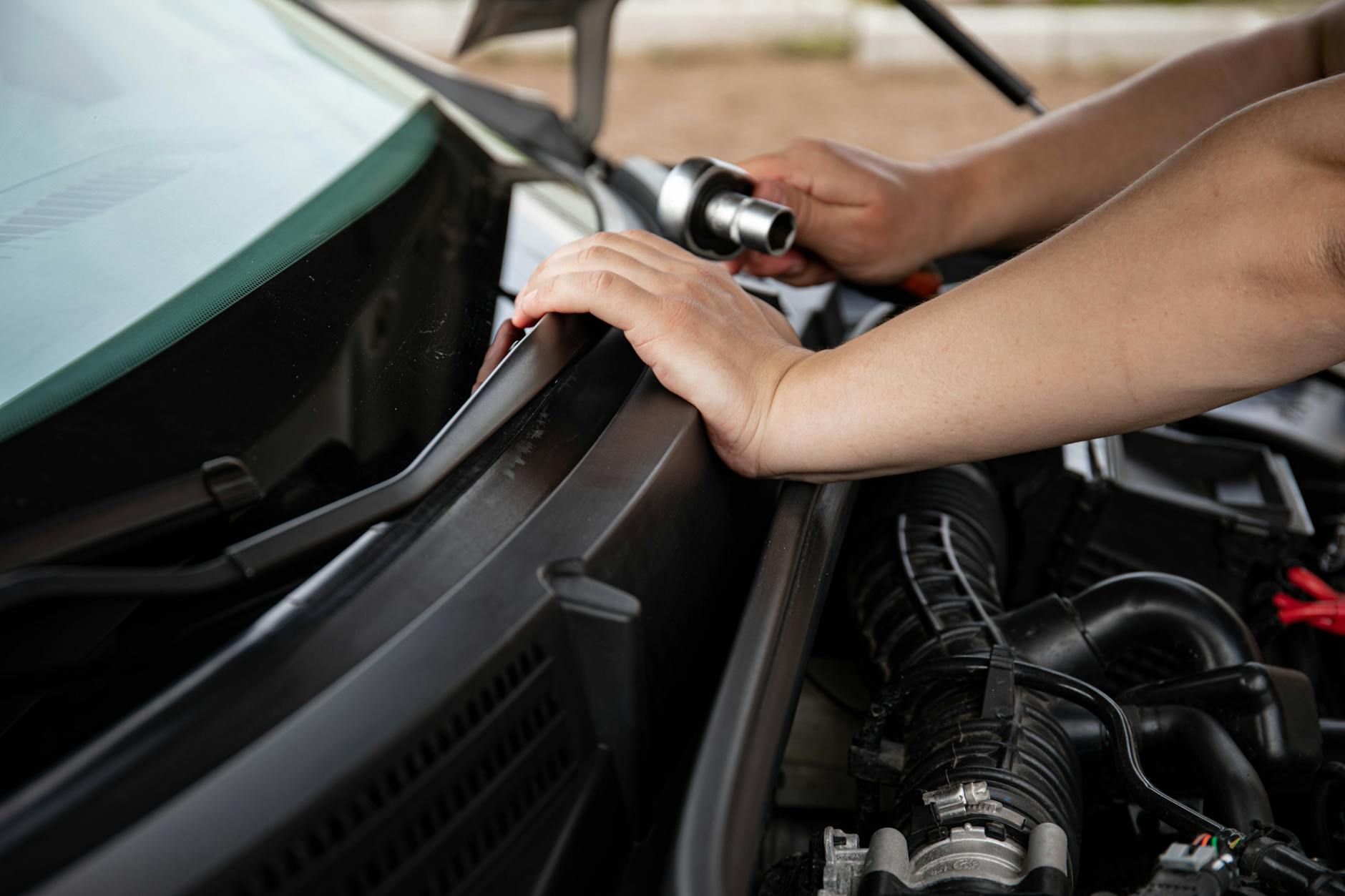 Mechanik dokręca śrubę w silniku Hyundaia kluczem nasadowym