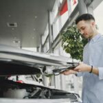 Cadillac XT5 używany: co sprawdzić przed zakupem i jak negocjować cenę Mężczyzna sprawdza silnik Cadillaca XT5 w salonie przed zakupem