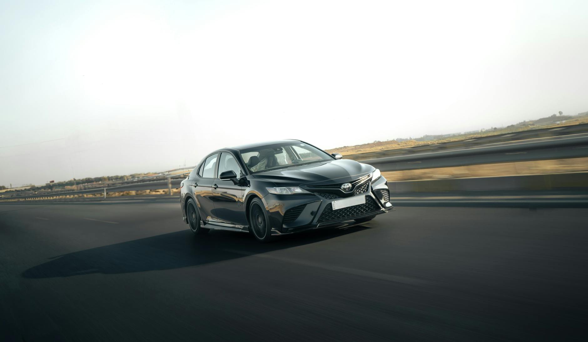 Srebrna Toyota Camry jedzie szybko autostradą