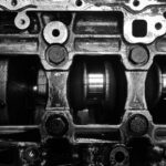 Dlaczego VW ma tyle oznaczeń silników: TSI, TFSI, TDI i co to znaczy w praktyce Czarno-białe zbliżenie metalowego wału korbowego silnika VW