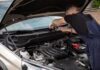 Citroën C3 używany: na co uważać przed zakupem? Mechanik naprawia silnik Citroëna C3 na zewnątrz w dzień