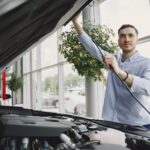 Jak sprawdzić Chevroleta po VIN: historia, wyposażenie i pułapki ogłoszeń Mężczyzna sprawdza silnik Chevroleta w nowoczesnym salonie samochodowym