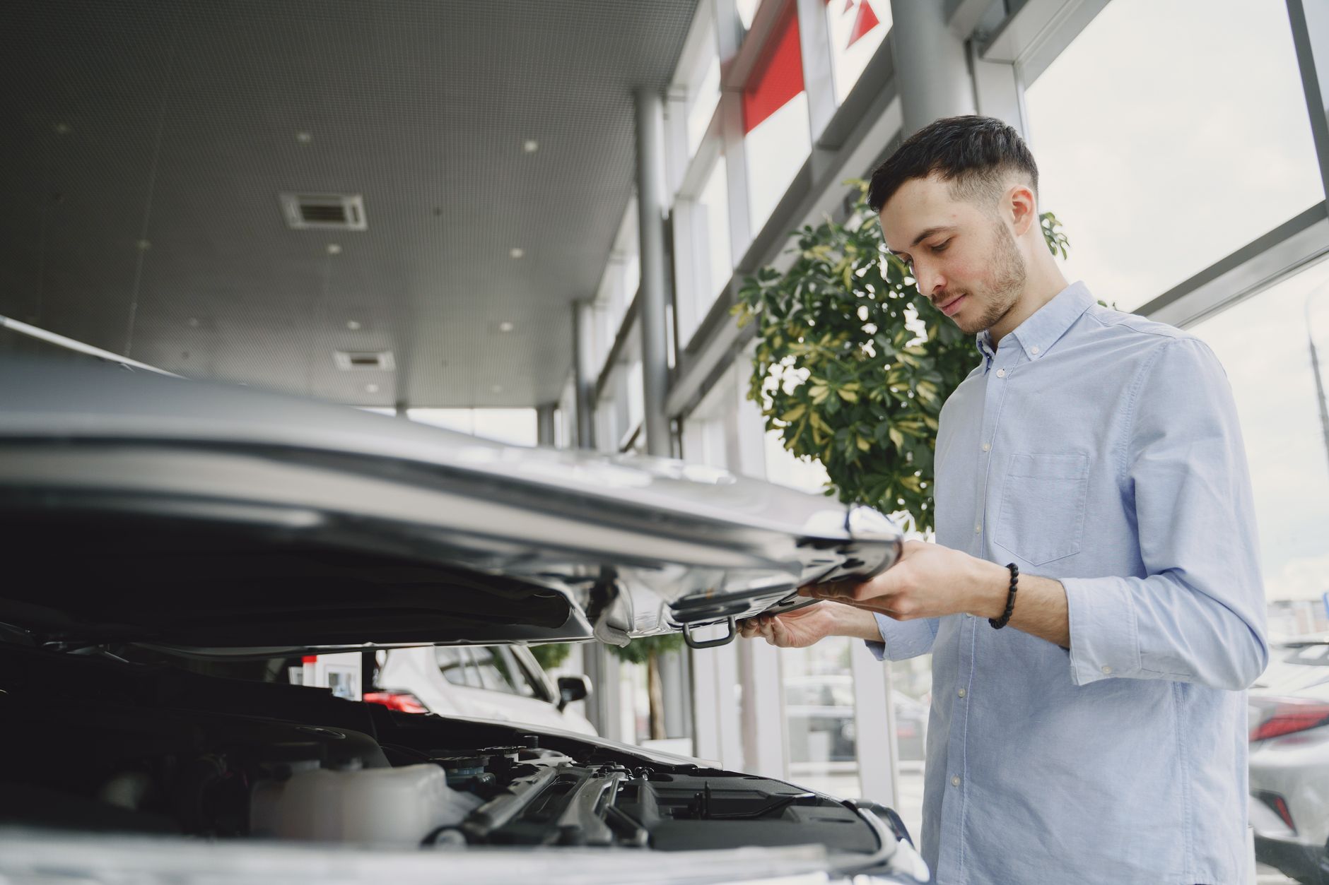 Mężczyzna sprawdza silnik Hyundaia Tucsona w salonie dealerskim