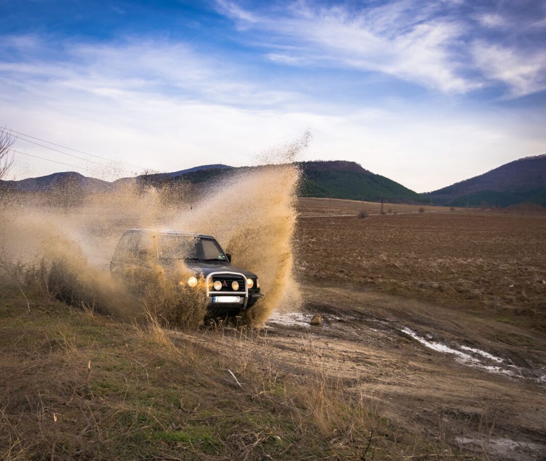 Dacia Duster 4x4 jadąca w błocie w terenie offroad Dacia Duster 4x4 jadąca w błocie w terenie offroad