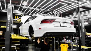 Mechanik serwisuje białe Maserati w nowoczesnym warsztacie