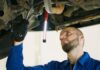 Mechanik serwisuje Forda Focusa pod podnośnikiem w warsztacie