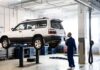 Renault Koleos: czy warto kupić używane SUV Renault i jak sprawdzić napęd 4×4? Mechanik sprawdza SUV na podnośniku w nowoczesnym warsztacie